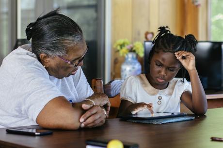Caretaker helps child with remote learning