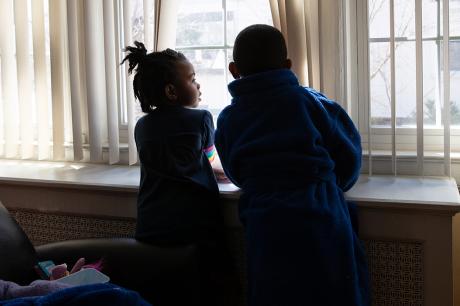 Children look outside a window