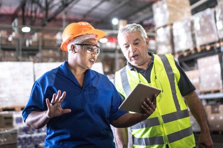 Older workers talk in a warehouse 
