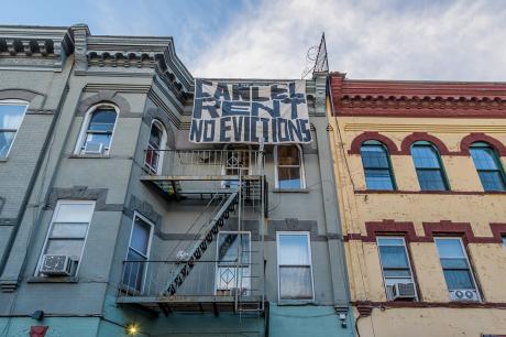 "Cancel rent no evictions" sign hangs from apartment building