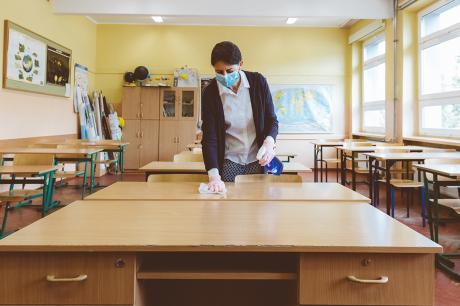 Teacher cleans a classroom