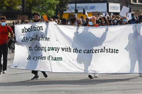 Protesters hold an "abolish" sign