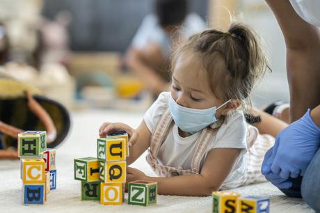 Child plays in a mask at day care