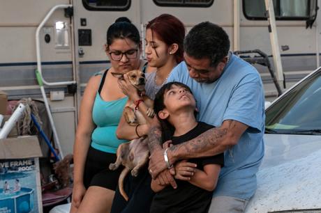 A family sits outside their RV