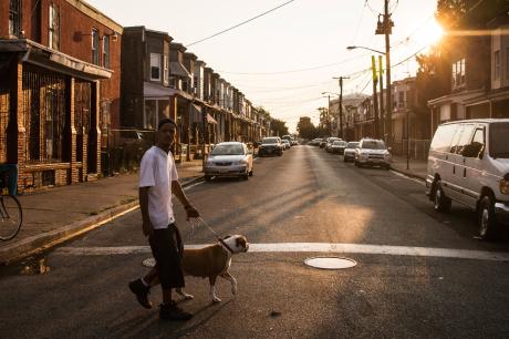 A man walks his dog in the Whitman Park neighborhood of Camden, New Jersey