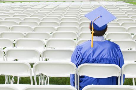 College graduate sits among empty chairs