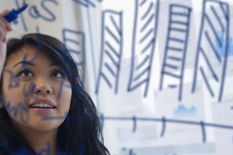 Woman writes with marker on clear board