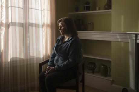 Woman sits in her house