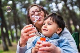 I gandmother and grandson blow soap bubbles. 