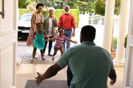 Children run into their house and into the arms of their father after a visit with their grandparents. 