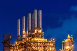 Factory smokestacks set ominously against the night sky 