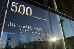 A close exterior shot of the Bill and Melinda Gates Foundation building at 500 5th Avenue North in Seattle, Washington, with a reflection of the Space Needle in the glass.