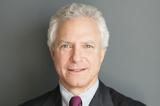 A photo of Jim Millstein. White hair, slight smile, suit and tie.
