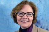 A photo of Patricia Mosser. Dark hair, glasses, bright smile.