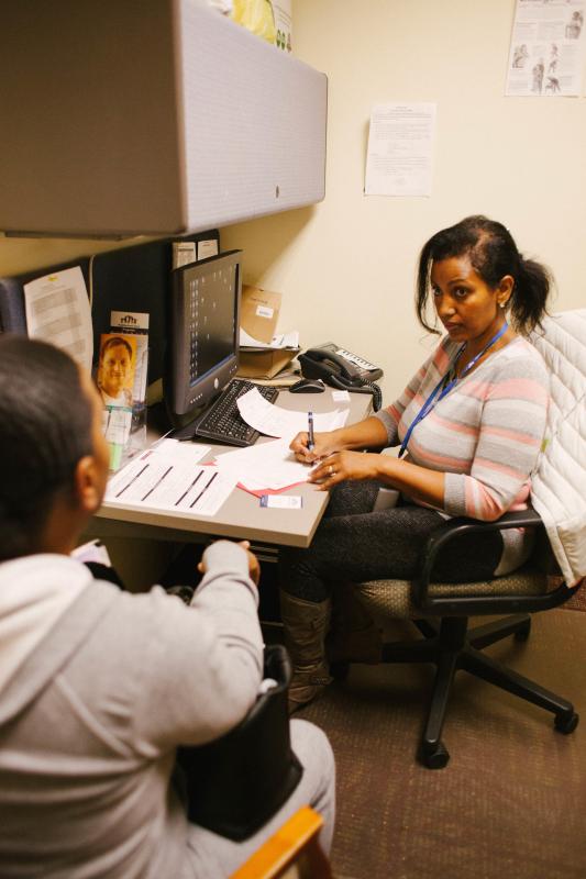 Frewoine Gebrehiwot, family coach and site coordinator at Neighborhood House, listens to a woman talk about why she and her children are facing the threat of eviction at the Crisis Clinic pilot.