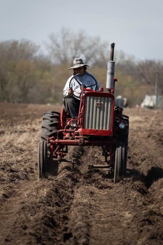 A person driving a red tractor.